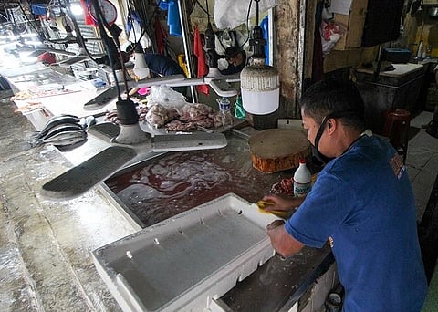 BAGUIO. A fish vendor at the Baguio City Public Market cleans his stall before closing. All vendors at the market have been practicing proper disinfection as a precautionary measure against the highly contagious Covid-19. (Photo by Jean Nicole Cortes)