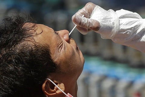 MANILA. A resident reacts as a health worker conducts a Covid-19 swab test as they monitor cases at a village in Quezon City on May 31, 2021. (AP)
