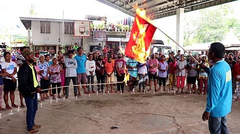 NEGROS. Residents of Barangay San Agustin in Isabela town burn the flag of the New People's Army to condemn its members' atrocities in a condemnation rally last week.
