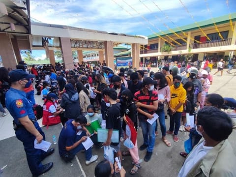 ZAMBOANGA. At least 29 people were injured in a stampede Saturday, August 20, 2022 at the entrance of a local public school when huge number of people gathered to avail of the Department of Social Welfare and Development's (DSWD) educational assistance. A photo handout shows a policeman stands watch while applicants fill up the form of their application to avail DSWD's educational assistance program. (SunStar Zamboanga)