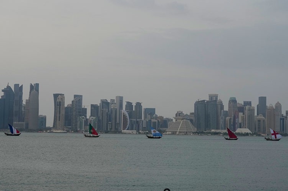 QATAR. Boats with flags of quarterfinal participating countries pass the skyline of Doha, Qatar, on Wednesday, December 7, 2022.