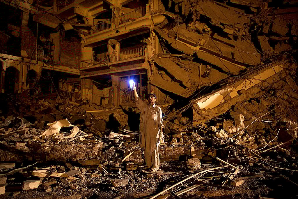A man sifts through the rubble in the wake of a bomb blast in Peshawar, Pakistan, in 2009. (Paula Bronstein/Getty Images)