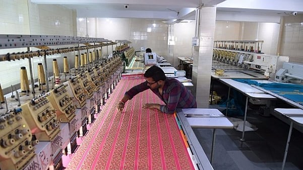 An Indian textile maker works on an embroidery machine at a workshop.(Representative Image | SAM PANTHAKY/AFP/Getty Images)