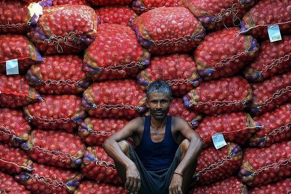 A labourer takes a break from unloading sacks of onions from a truck. (Sanjay Kanojia/AFP/Getty Images)