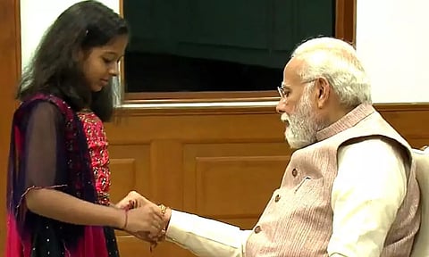 ரக்ஷா பந்தன் பண்டிகையை முன்னிட்டு பிரதமர் மோடிக்கு ராக்கி கயிறு கட்டி குழந்தைகள் வாழ்த்து