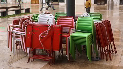 Stacked tables and chairs are pictured outside a coffee shop in Burgos, northern Spain