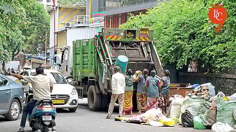 A large dumper is being deployed in the alley in front of SNDT College every morning to sort and collect waste.