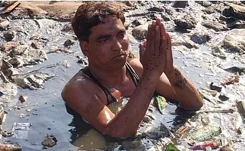 कानपुरः दलित बस्ती की अनदेखी को लेकर नाले में उतरकर प्रदर्शन करता दलित युवक।