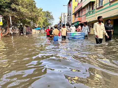 People walking through waterlogged streets in Chennai