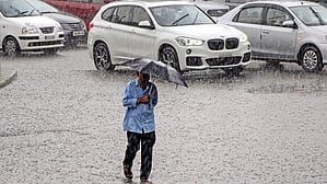 A representative image of a man walking with an umbrella while it rains