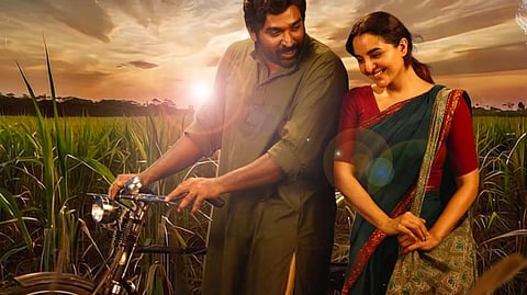 An image from the poster of Viduthalai Part 2 with Vijay Sethupathi and Manju Warrier speaking candidly to each other in the backdrop of a field.