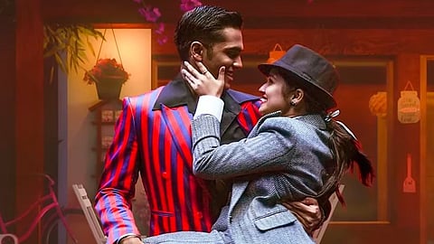 Pavish and Anikha dressed up in pantsuits, embracing each other against the backdrop of a street. The image is a screenshot from a song in the film.