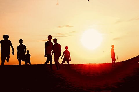 The local youth in Thiruvananthapuram begin a football game on the beach as the sun begins to go down. 