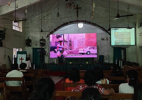 A group of people watching a screening of the film Occupied (2020) inside a church.