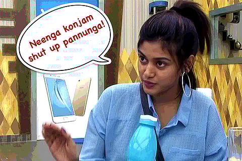A woman wearing a blue shit and holding a blue bottle. A speech bubble shows her saying, "You shut up for a while" in Tamil