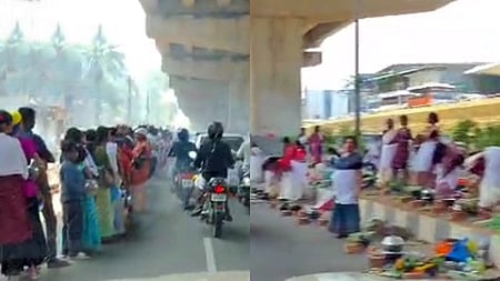 Women in traditional attire participate in the Attukal Pongala festival under a flyover, preparing offerings in earthen pots. 