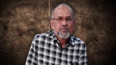 Zakhir Hussain Bijli wearing a checked shirt, wearing spectacles.