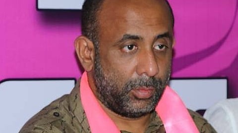BRS leader Shakil Aamir wearing a brown shirt and a pink party scarf