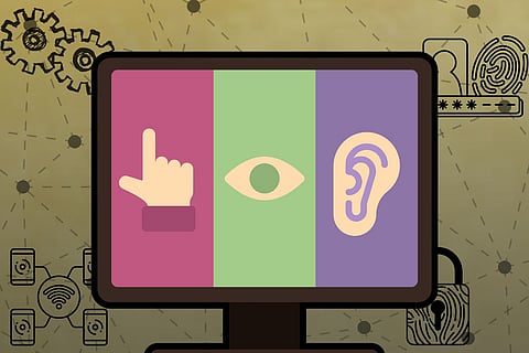 A computer monitor displays three vertical colored panels. From left to right: A pink panel with a hand icon pointing upward (representing touch or interaction), a green panel with an eye icon (representing vision) and a purple panel with an ear icon (representing hearing). The background includes various technology-related icons, such as gears, fingerprint scanners, padlocks, Wi-Fi, and connected devices, suggesting themes of accessibility, technology, and user interaction.