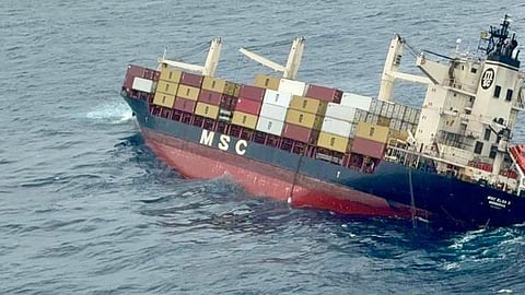 The image shows the container vessel, tilted to the right, in the sea.