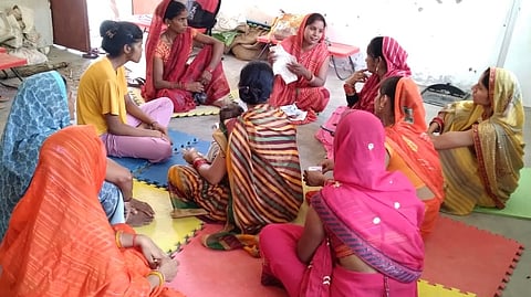 A digital didi in Uttar Pradesh explaining how to use a reusable cloth pad to the women of her community 