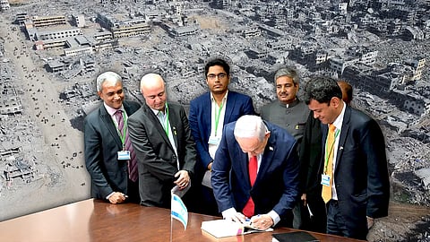 Netanyahu surrounded by Indian journalists. In the background is a war-torn Gaza