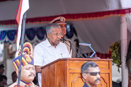 Image featuring Pinarayi Vijayan wearing a white shirt and addressing the audience.