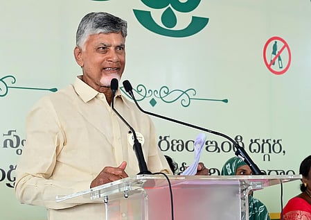 Chandrababu Naidu in an off-white shirt speaking from a podium