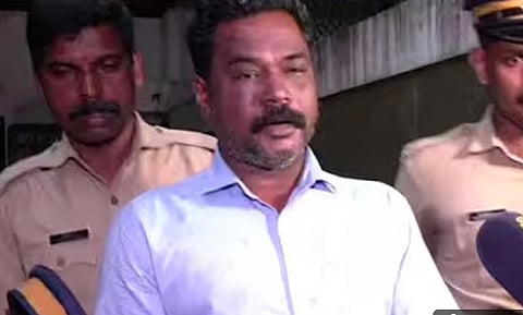 Image featuring Sunoop, wearing a white shirt, along with police officers 