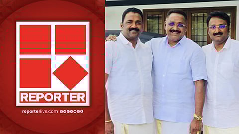 Reporter TV logo displayed on a red background, alongside three men dressed in white shirts and traditional Kerala mundu attire, standing together and smiling for a photo.