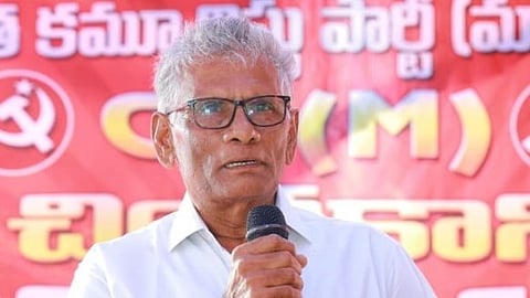 Communist Party of India (Marxist) leader Samineni Ramarao with a mic in hand speaking on a stage 