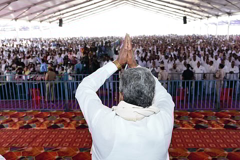 Karnataka Chief Minister Siddaramaiah greets his supporters at a gathering.