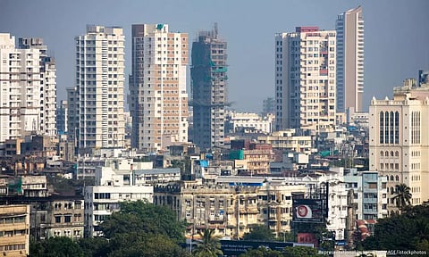 The skyline of an Indian city, with low rise buildings in the foreground and skyscrapers behind
