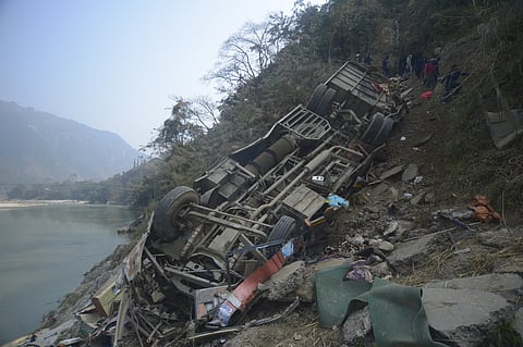 The wreckage of a bus is seen on the bank of the Trishuli River after it drove off a mountain highway near Benighat, west of the capital, Kathmandu, Nepal, Monday, Feb. 23, 2026. 