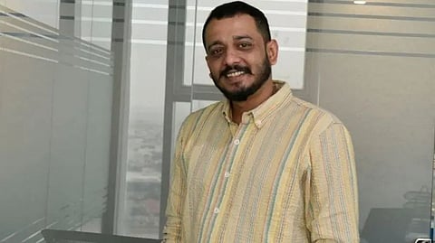 A headshot of Chidambaram in a yellow shirt