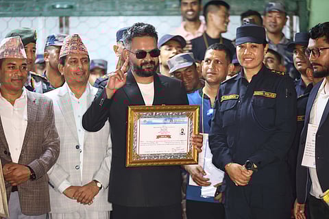 Balendra Shah, foreground, former mayor of Kathmandu Metropolitan City and prime ministerial candidate of the Rastriya Swatantra Party, receives his victory certificate after defeating former Prime Minister Khadga Prasad Oli of the Communist Party of Nepal–Unified Marxist-Leninist (CPN-UML) in Jhapa, about 267 miles (430 kilometers) southeast of Kathmandu, Nepal, Sunday, March 8, 2026. 