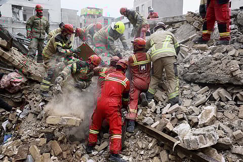 Rescue workers search for survivors in the rubble after a strike in southern Tehran, Iran, Friday, March 13, 2026. 