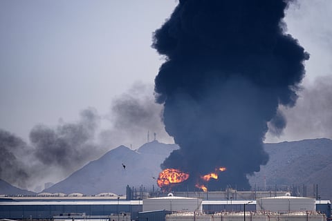 A fire and plume of smoke rise after, according to authorities. debris from an intercepted Iranian drone struck an oil facility in Fujairah, United Arab Emirates, Saturday, March 14, 2026.