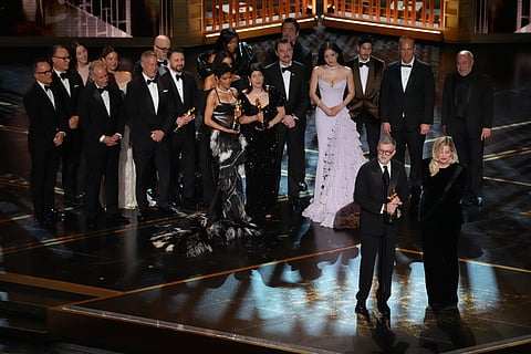 Paul Thomas Anderson, left center, Sara Murphy, right center, and the team from "One Battle After Another" accept the award for best picture during the Oscars on Sunday, March 15, 2026, at the Dolby Theatre in Los Angeles. (AP Photo/Chris Pizzello)

