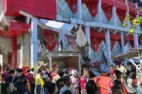 Onlookers gather as police officers inspect a damaged building following an earthquake in Manado, North Sulawesi, Indonesia, Thursday, April 2, 2026. 