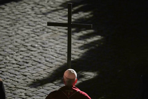 Pope Leo XIV carries a lightweight, 1.5-meter (5-foot) wooden cross during the Via Crucis, the torchlit Good Friday Stations of the Cross procession at the Colosseum in Rome, Friday, April 3, 2026, which symbolically retraces Jesus Christ's steps to his crucifixion on Calvary in Jerusalem. 