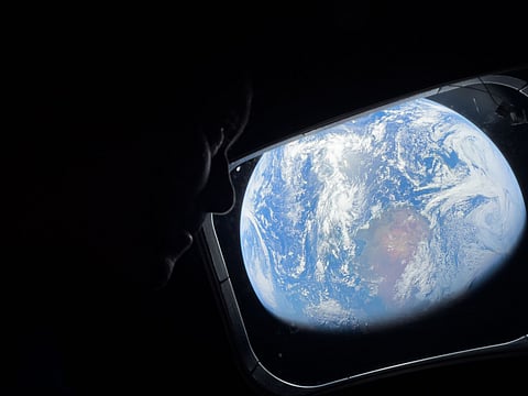 In this photo provided by NASA, Commander Reid Wiseman looks at the Earth from a window aboard the Orion spacecraft Integrity during the Artemis II mission en route to the moon on Thursday, April 2, 2026. 