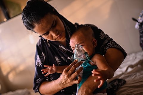 A mother administers a nebulizer treatment for her child suffering from measles at the Infectious Diseases Hospital in Dhaka, Bangladesh, Monday, April 6, 2026, amid a countrywide outbreak. (AP Photo/Mahmud Hossain Opu)

