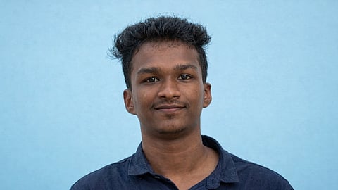 Portrait of Nithin Raj, a young man wearing a dark shirt, against a blue background.