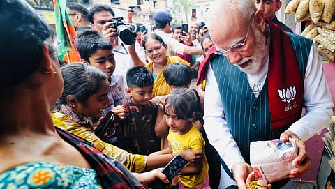 Prime Minister Narendra Modi shares Jhal Muri to women in West Bengal's Jhargam during campaigning.