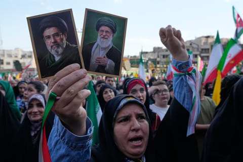 A woman holds up pictures of the Iranian Supreme Leader Ayatollah Mojtaba Khamenei, left, and his father, the slain Ayatollah Ali Khamenei in a state-organised rally celebrating the birthday of Imam Reza, the 8th Shiite Muslims' Imam, and supporting the supreme leader, in Tehran, Iran, Wednesday, April 29, 2026. (AP Photo/Vahid Salemi)

