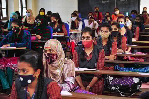 Students sitting in a classroom wearing masks