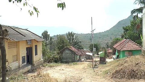 A few tiled houses and a warehouse with a corrugated roof in a village