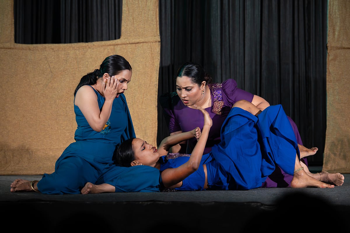Three women on stage, mid performance.