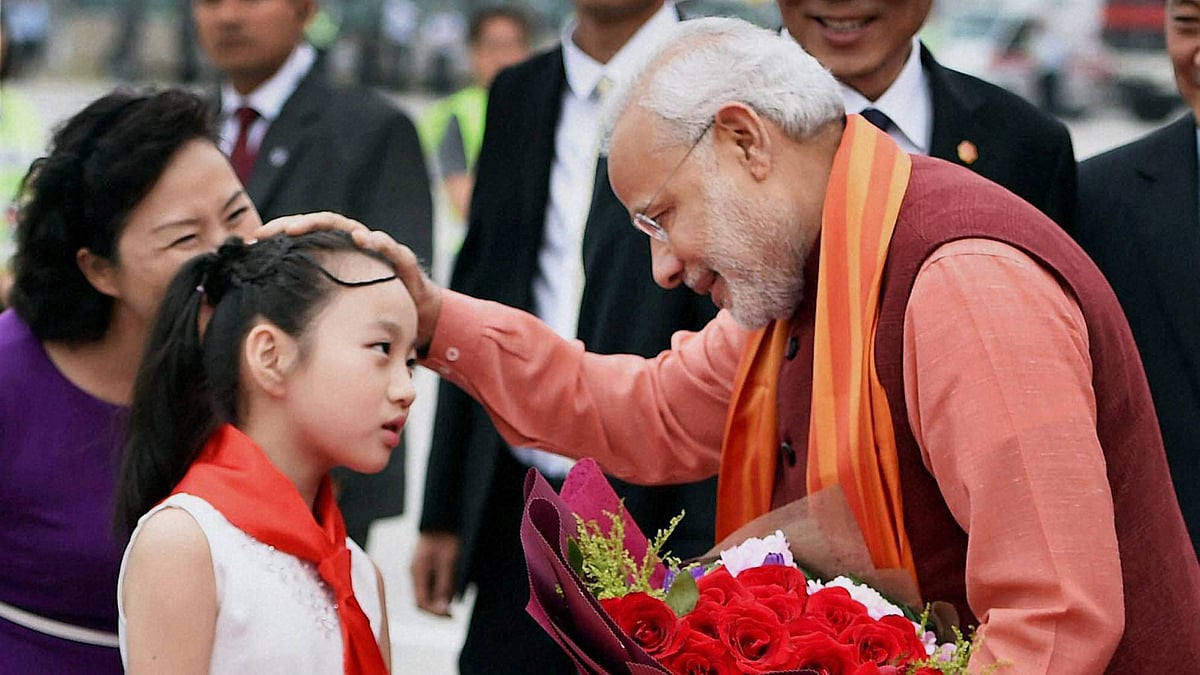 Prime Minister Narendra Modi being welcomed by a Chinese girl child on his arrival at Xi’an Xiangyang International Airport, in China. (Photo: PTI)